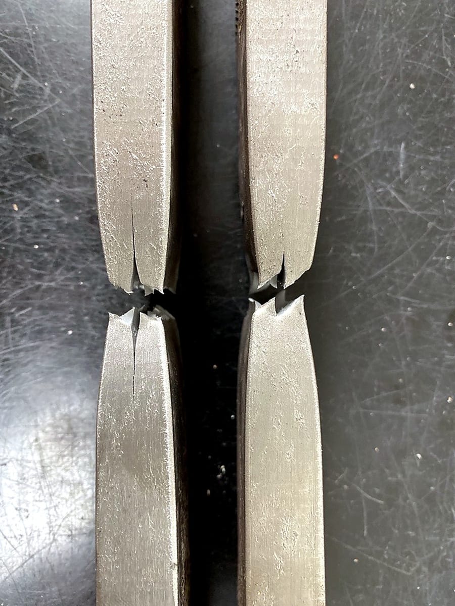 Two tensile test specimens after testing, fractured through the reduced section.