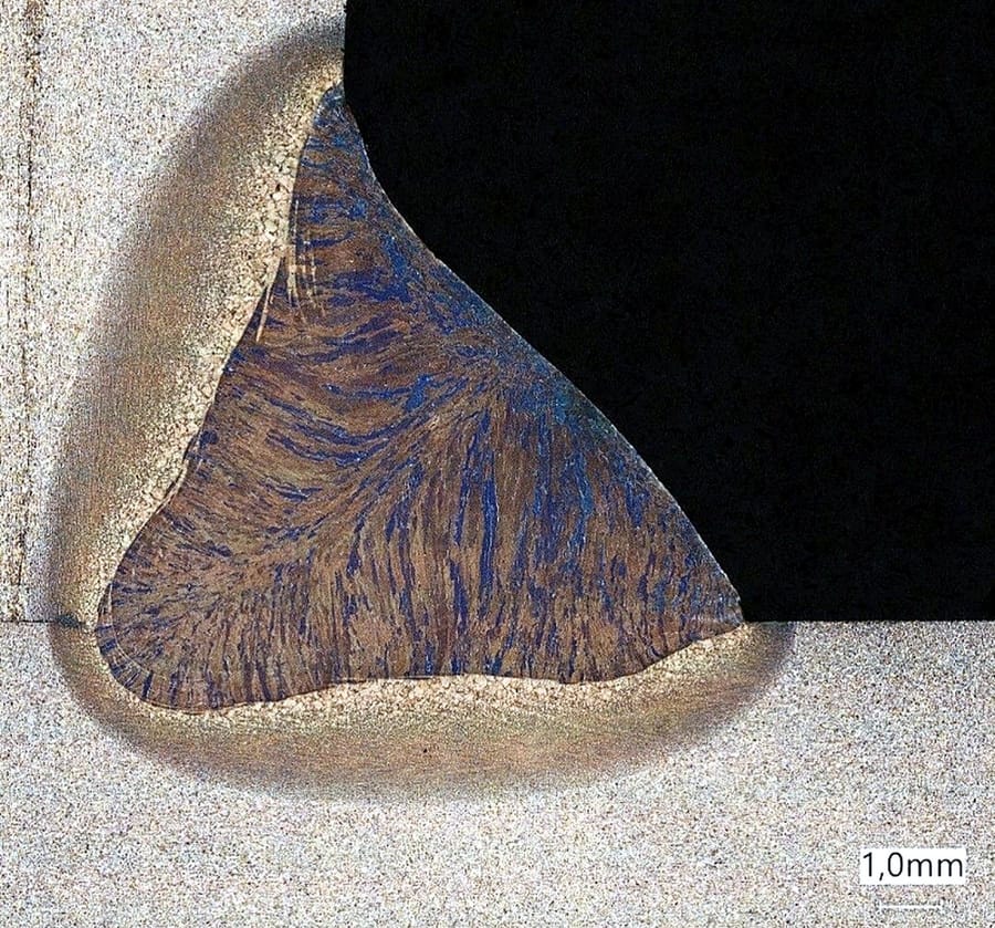An etched weld macro section showing the fusion line and heat affected zone against a one millimetre scale.
